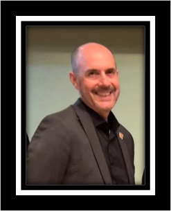 Portrait de Sébastien Tremblay, conseiller municipal, un homme chauve et souriant avec une moustache.